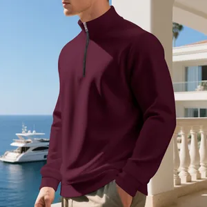 Felpa da uomo bordeaux con mezza zip in una lussuosa cornice all'aperto di un resort