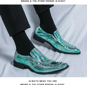 Close-up detail of iridescent green snake-patterned loafers with metal studs.