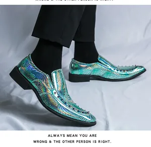 Detail view of holographic blue snake-skin loafers featuring studded pointed toe.