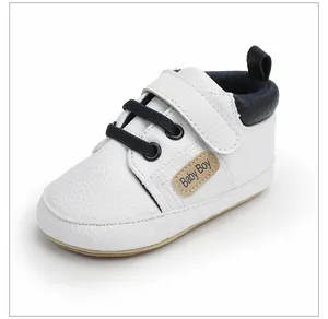 Primer plano de zapato de aprendizaje blanco para bebé con cordones azul marino.