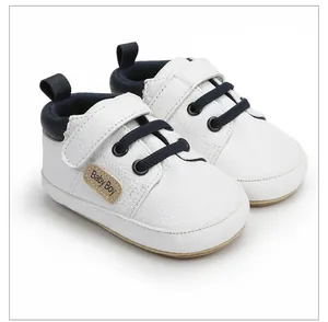 Detalle de zapatos para bebé niño de piel blanca con cierre de velcro en azul marino