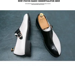 Primo piano di scarpe eleganti bicolore bianco e nero da uomo con fibbia dorata lucida