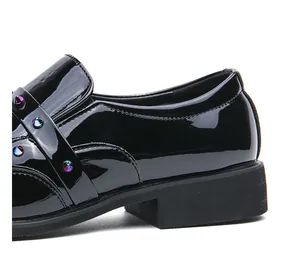 Macro view of black patent leather loafer with colorful rivet details on the strap.
