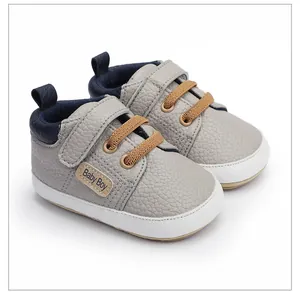 Primer plano de zapatos de marcha grises para bebé con suelas blandas y cierre de velcro.