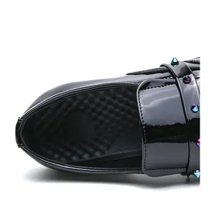 Macro detail of black patent leather loafer with colorful studs and honeycomb lining.