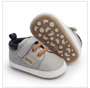 Primer plano de zapatos grises para bebé con suela antideslizante suave y textura de cuero.