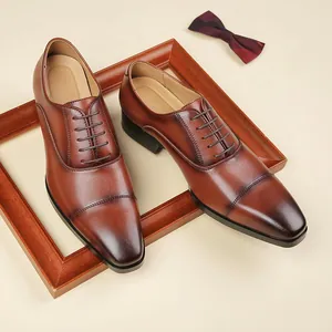 Elegant men's brown cap-toe leather business shoes with lace-up design in a studio setting
