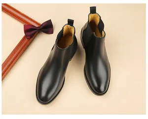 Detailed view of black leather men's Chelsea boots with classic elastic side panels