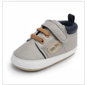 Detalle de zapatos de marcha grises para bebé niño con velcro y suela suave antideslizante.