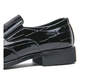 Close-up detail of black crocodile embossed patent leather loafer with glossy finish