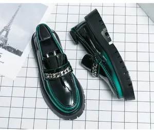 Détail des mocassins en cuir verni vert et noir avec chaîne argentée et semelle épaisse