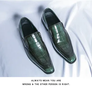 Detail view of dark green patent leather loafers with crocodile embossed pattern.