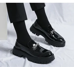 Vue détaillée de mocassins en cuir verni noir avec semelle épaisse et chaîne