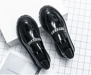 Détail de mocassins noirs vernis pour hommes avec semelle plateforme et chaîne argentée