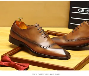 Detail of men's brown leather brogue shoes with elegant wingtip perforation detail.