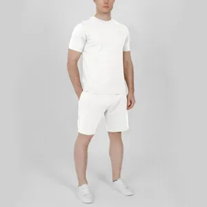 Man wearing a solid white casual summer short sleeve T-shirt and shorts set in studio