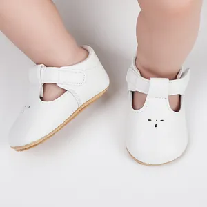 Detailed macro view of white infant T-strap walker shoes featuring cat-face perforations