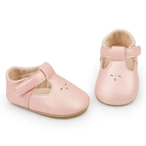 A detailed view of pink leather T-strap baby princess walking shoes with floral cutouts