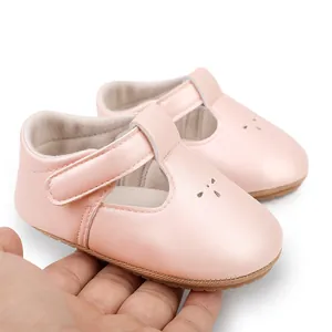 Detailed view of pink T-strap baby walking shoes featuring decorative cutouts and velcro strap