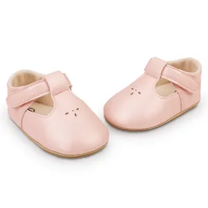 Detail of pink baby walking shoes with T-strap and hook-and-loop closure for girls