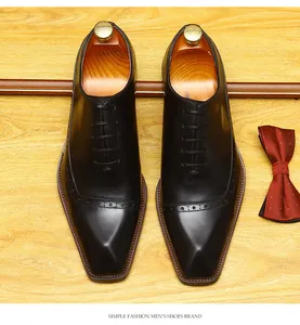 Detailed overhead view of black leather brogue shoes with classic wingtip wing-tip perforations