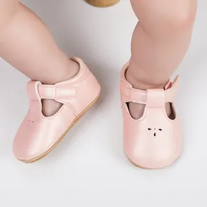 Close-up view of pink leather infant walking shoes with adjustable T-strap velcro closure