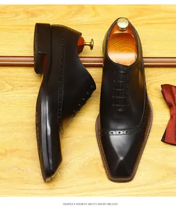 Detailed high-angle view of black leather brogue oxford shoes with wooden shoe trees