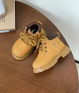 Détail de bottines Martin classiques jaunes pour enfants avec semelles souples sur bois