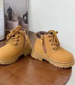 Gros plan de bottines Martin jaunes pour enfants avec fermeture éclair latérale.