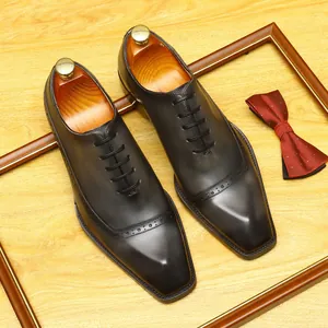 Elegant men's leather brogue oxford shoes with wingtip detailing in a business formal style.