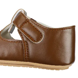 Detail view of brown leather baby girl shoes with fine stitching and velcro strap