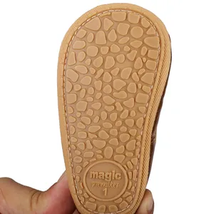 Close-up of non-slip rubber sole with pebble texture on baby girl's prewalker shoe