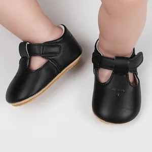 Close-up of black infant princess shoes with T-strap and velcro closure on feet