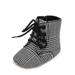 Détail de bottines pour bébé à semelle souple avec motif pied-de-poule noir et blanc