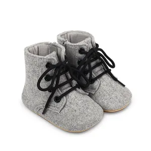 Gros plan de bottines de marche pour bébé en feutre gris avec lacets noirs et fermeture éclair