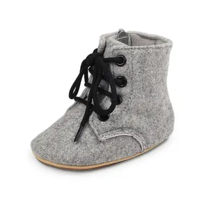Vue détaillée de bottines pour bébé en feutre gris avec lacets noirs et fermeture éclair
