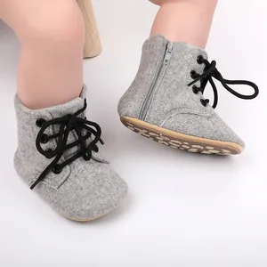 Vue détaillée de bottines de marche grises pour bébé avec fermeture éclair et lacets noirs