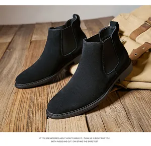 High-quality close-up of men's black suede Chelsea boots on a rustic wooden surface