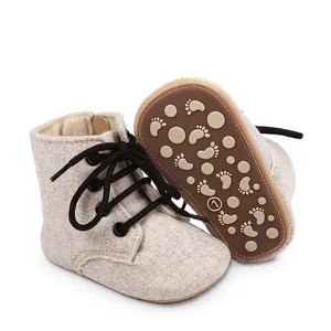 Vue détaillée de chaussures de marche bébé antidérapantes avec lacets noirs.