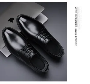 Top view of glossy black leather men's dress shoes with laces on a sleek dark surface.