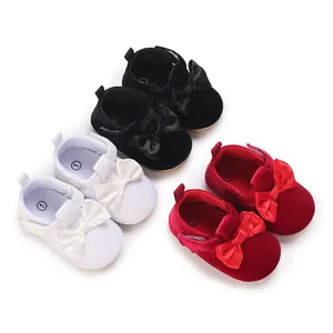 Group of soft-sole baby walking shoes with satin bows in black, white, and red velvet