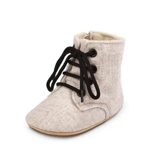 Vue détaillée de bottines de marche pour bébé en tissu beige avec lacets noirs