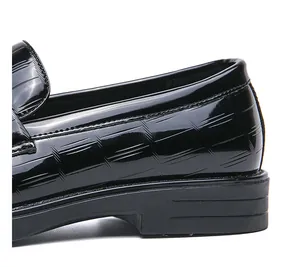 Close-up of black patent leather loafer with crocodile texture and sturdy heel