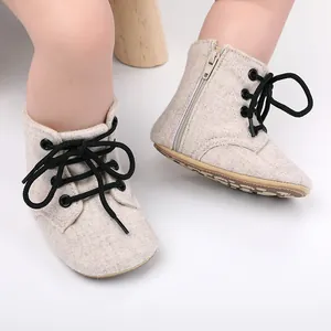 Vue détaillée de bottines de marche pour bébé en toile avec fermeture éclair et lacets.