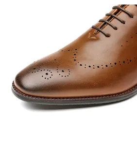 Close-up detail of brown leather brogue shoes with hand-painted burnished toe design