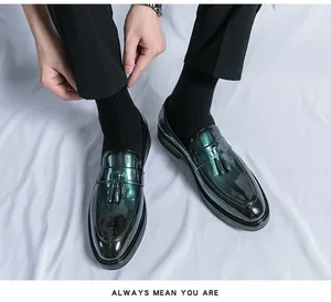 Close-up of green patent leather tassel loafers for men on white background