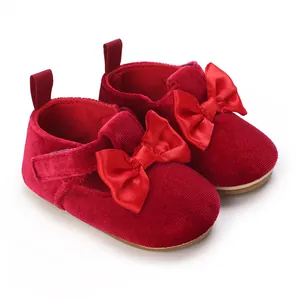 Detail of red velvet baby walking shoes with satin bow for infants aged 0-1 year