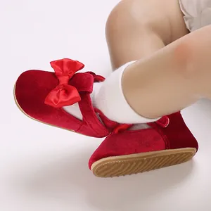 Detail shot of red velvet baby walking shoes with bow accent and soft anti-slip sole.