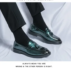 Detailed view of men's dark green metallic loafers with tassel and croc-emboss.