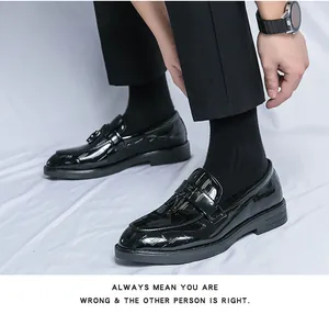 Close-up detail of black shiny tassel loafers with patent leather finish for men